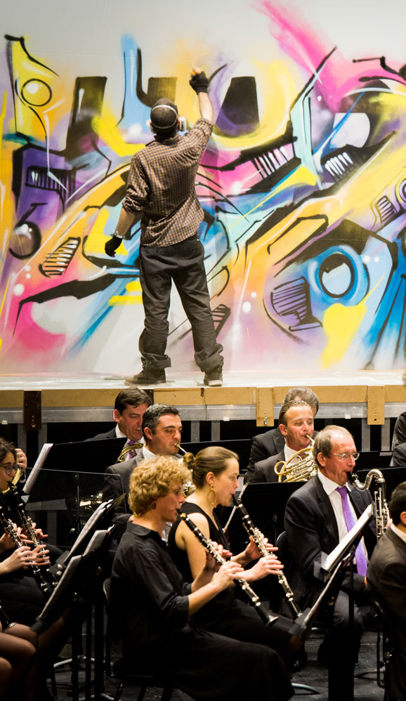 Alex Kanos is painting during Harmonic Orchestra Concert